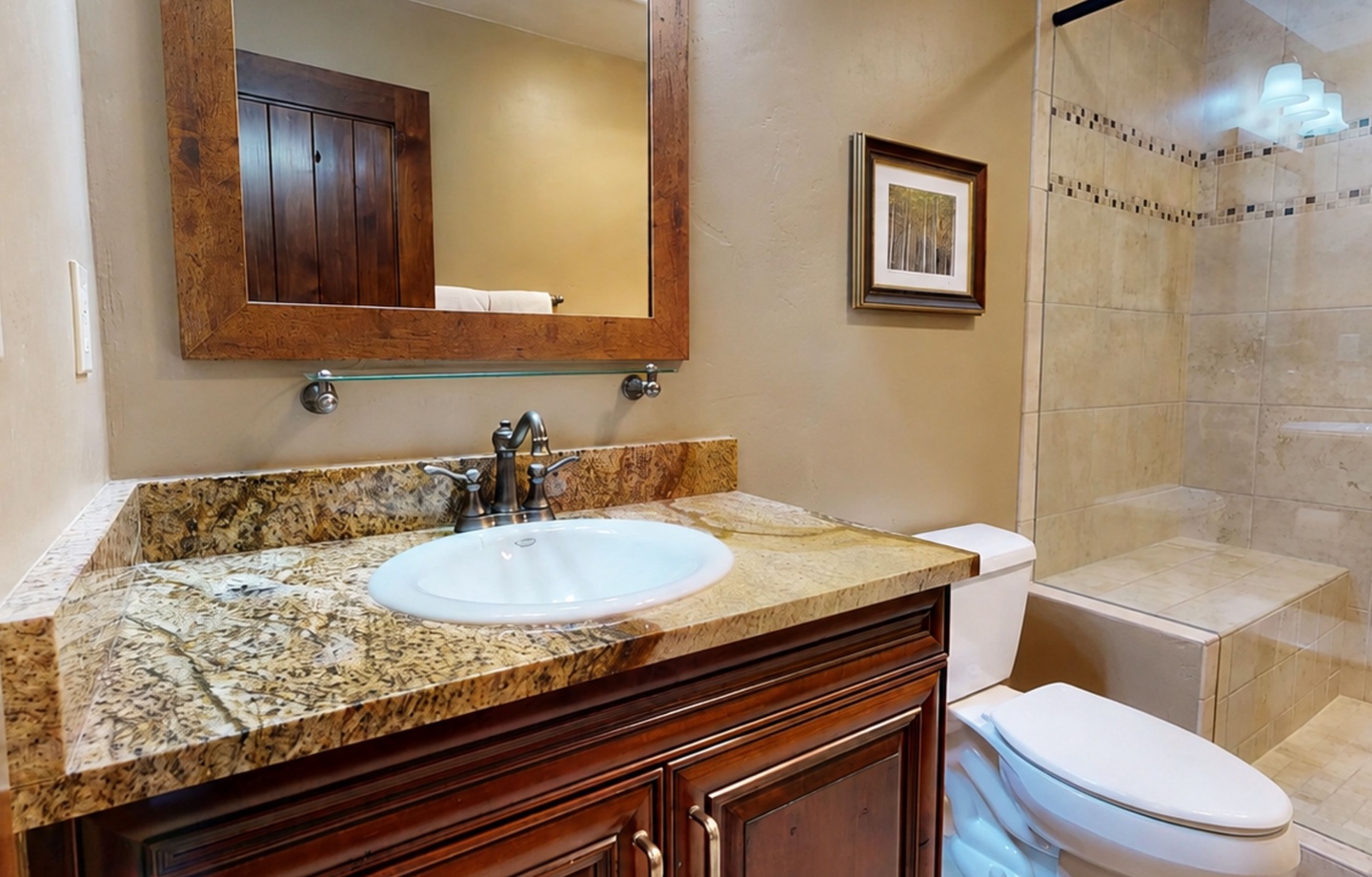 Refresh in your elegantly appointed bathroom featuring granite countertops, a walk-in shower, and warm wood accents that create a spa-like retreat after your mountain adventures.