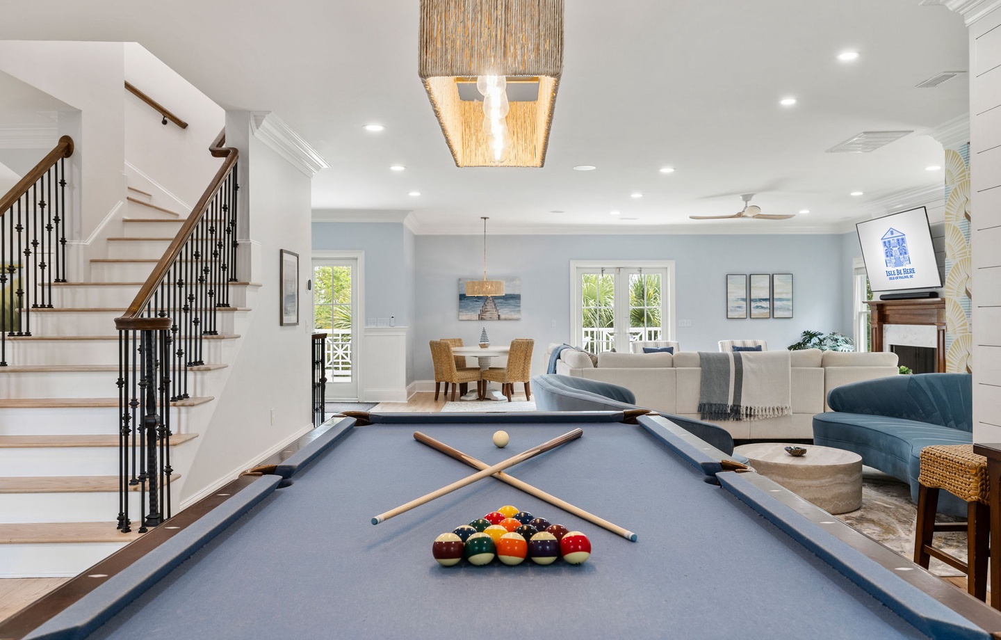 Challenge friends to billiards in your open-concept entertainment space, where coastal charm meets modern comfort beneath striking woven lighting.