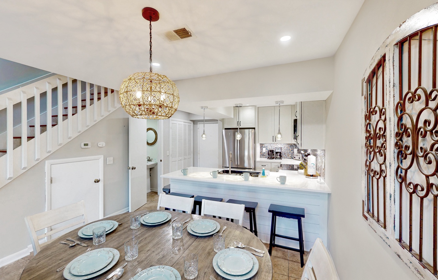 You'll love gathering around this bright, coastal-inspired dining and kitchen space. The open layout and charming touches create a welcoming spot for meals together.