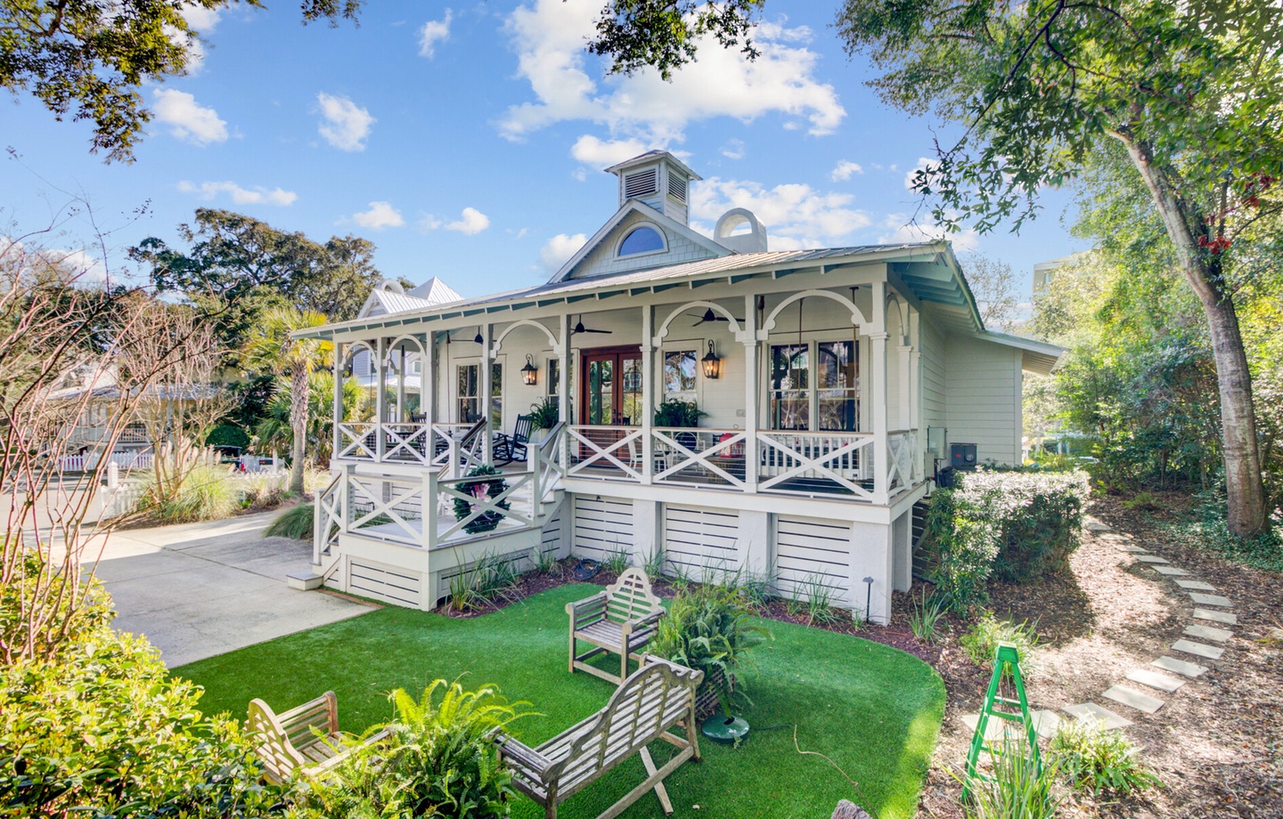 Charming cottage features wraparound porch and private garden oasis with lush landscaping and peaceful seating areas.