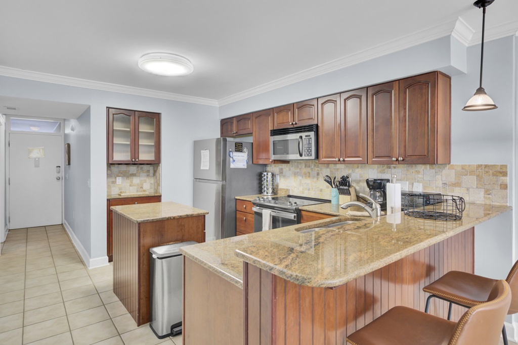 - Spacious kitchen with rich wood cabinetry & sleek stainless appliances - Granite countertops, a center island, & breakfast bar offer plenty of space to prep, & serve - Whether you're brewing coffee or hosting a happy hour, this kitchen has you covered