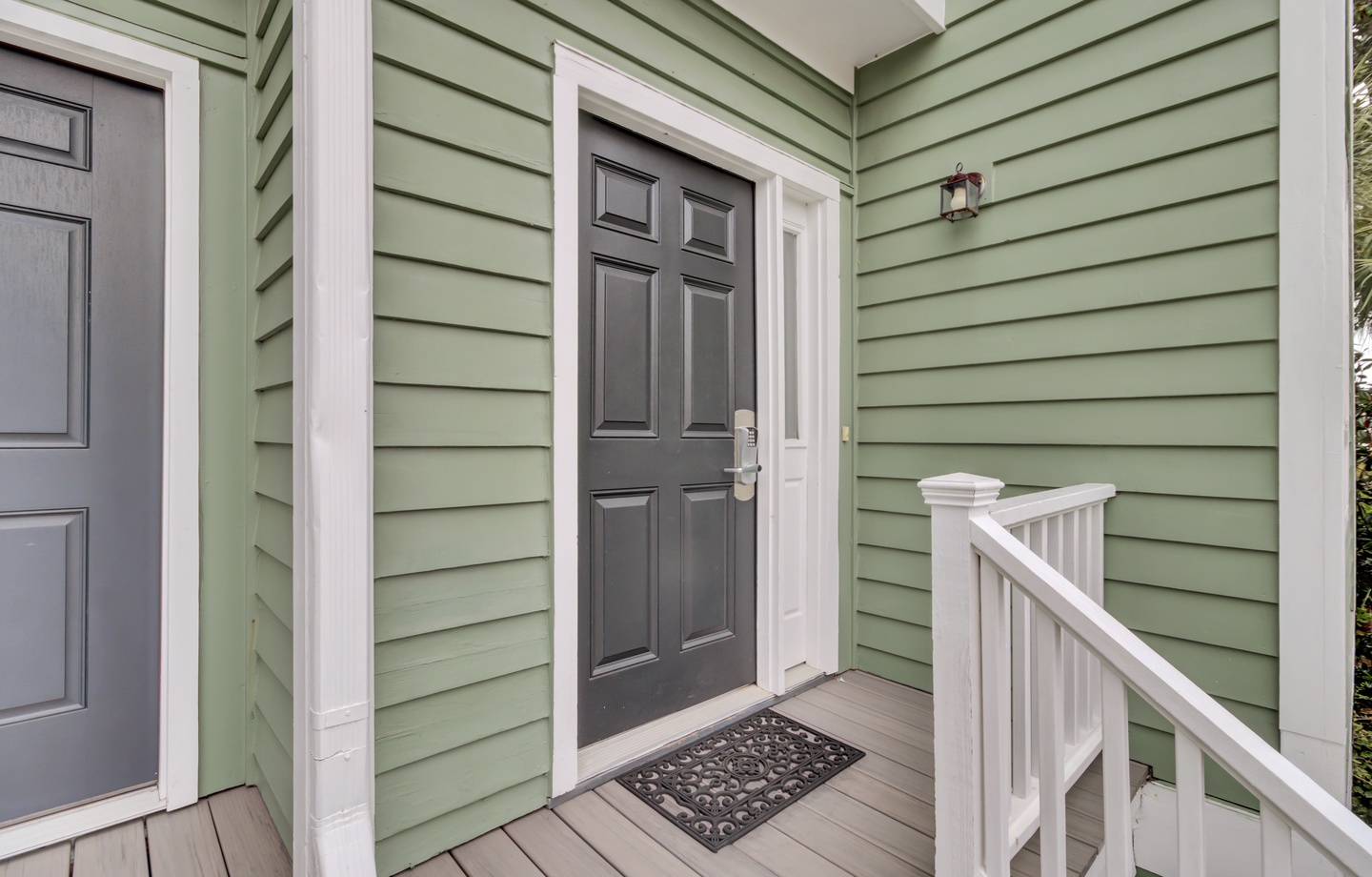 Charming green cottage entrance with classic details and welcoming covered porch creates an inviting first impression.