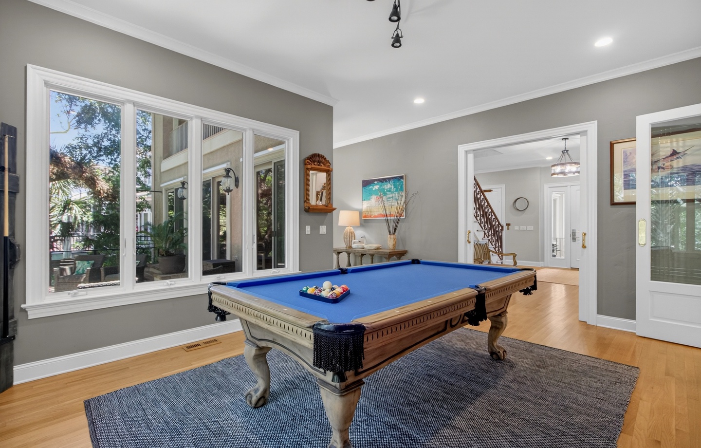 Your private game room awaits with a classic billiards table, perfect for friendly competition and evening entertainment in this elegant, light-filled space.