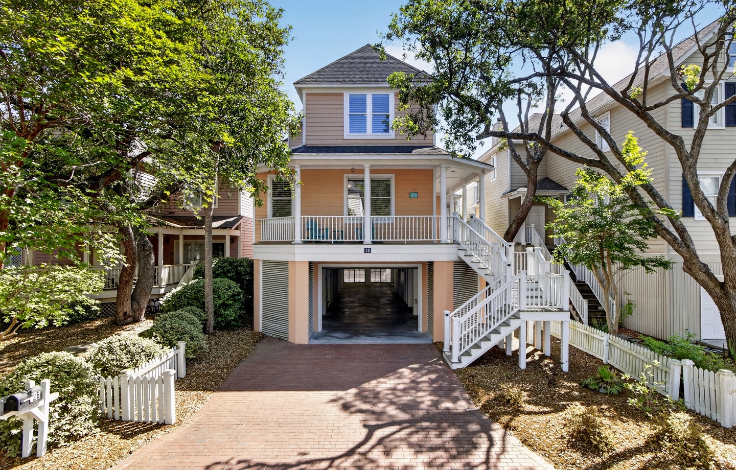 Charming coastal property nestled among mature trees with covered parking and stairs leading to your elevated beach retreat.
