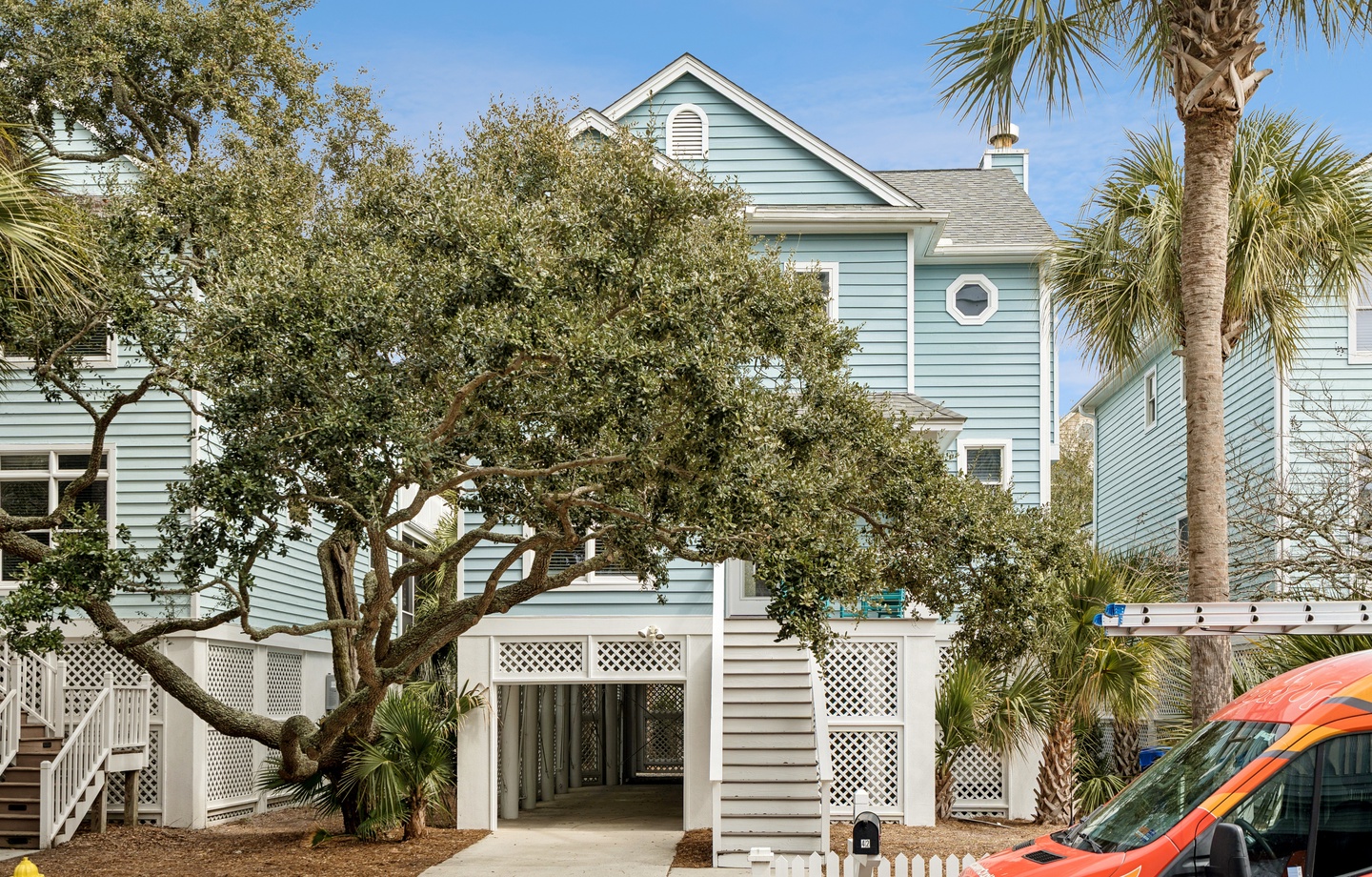 Charming coastal cottage with tropical landscaping and convenient covered parking in a peaceful residential setting.