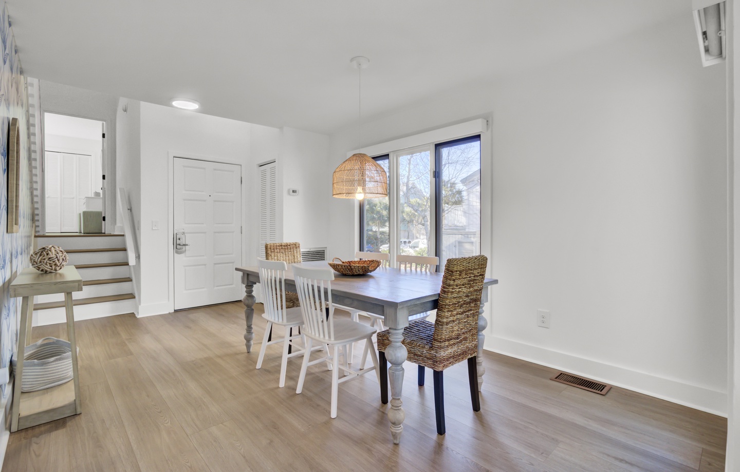 Gather around your bright dining space where natural light streams through large windows, creating the perfect spot for morning coffee or evening meals together.
