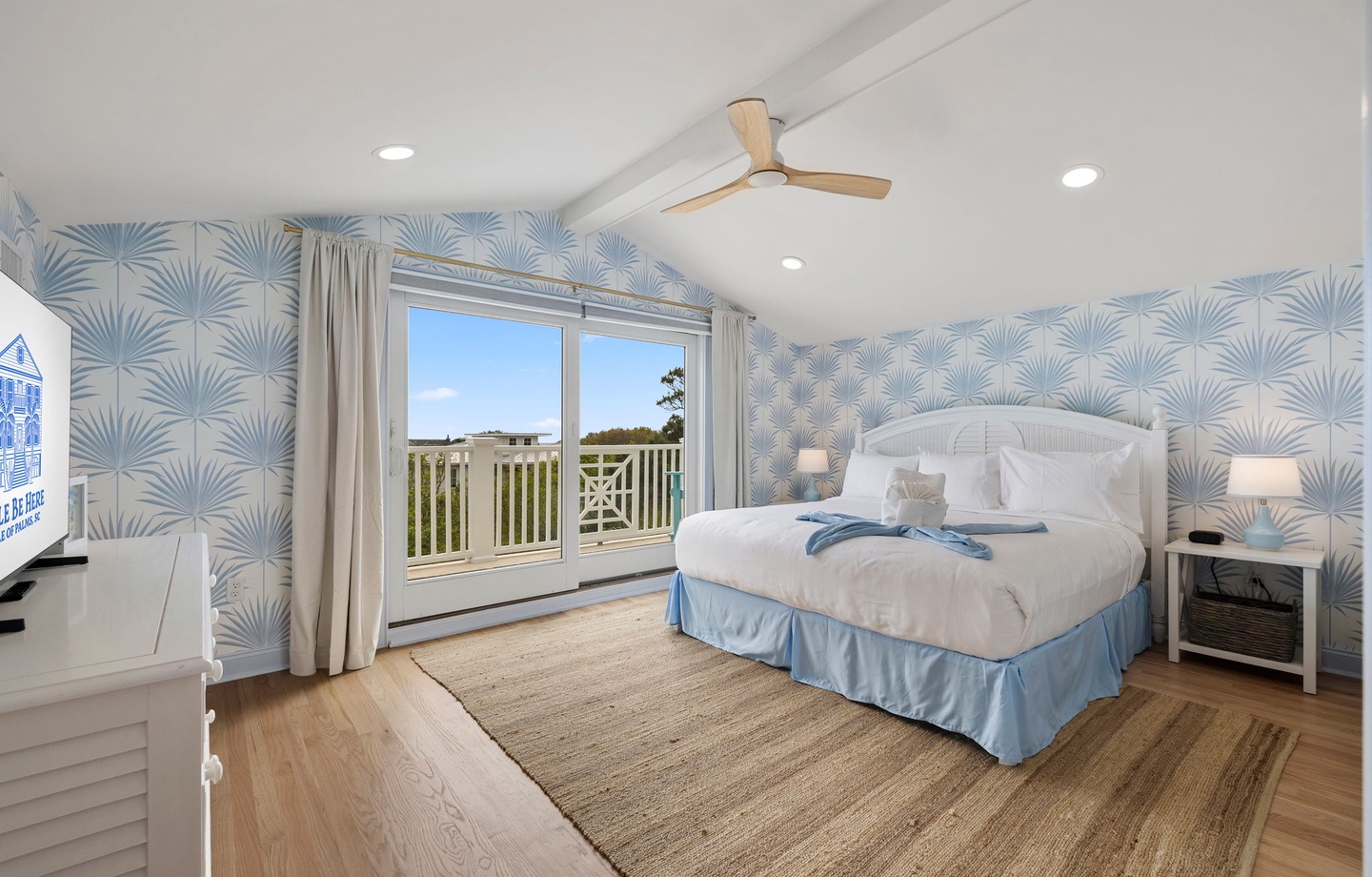 Drift to sleep in your coastal haven with tropical palm wallpaper and natural light streaming through doors to your private balcony.