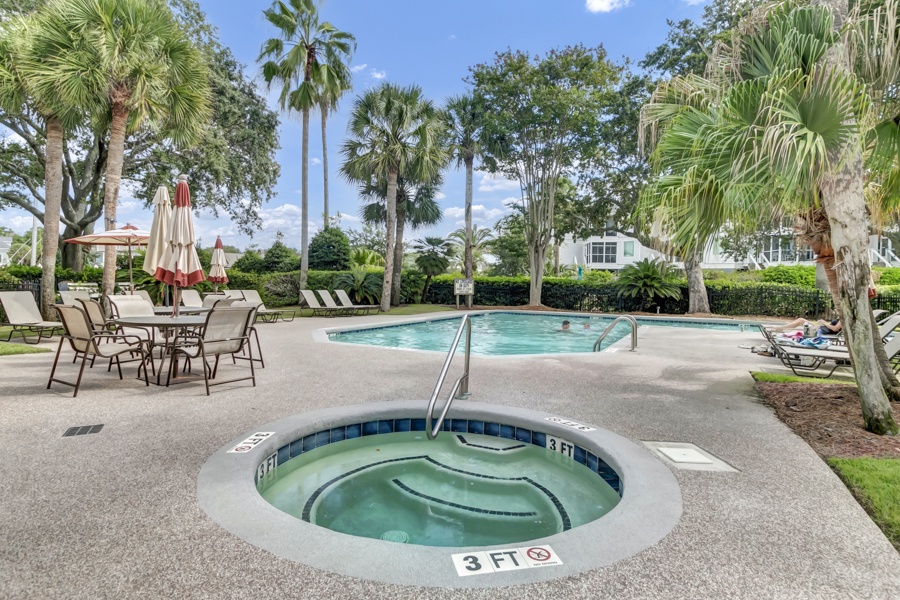 Lush palm trees frame the property's inviting pool and hot tub area, where sunny lounging and poolside dining await. A perfect tropical escape right on the grounds.