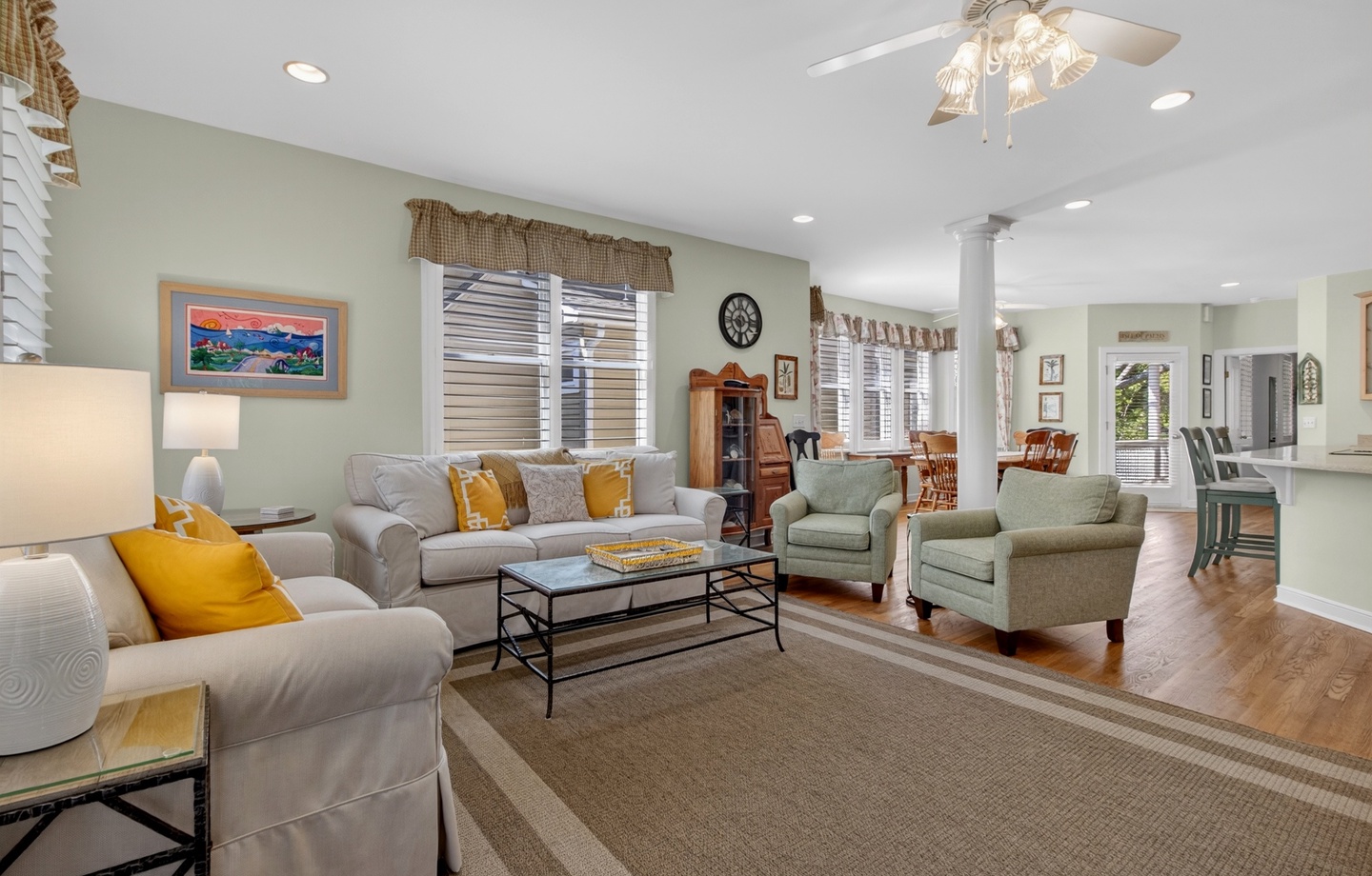 Sink into plush sofas in your spacious living room, where golden accents and coastal art create the perfect retreat atmosphere.