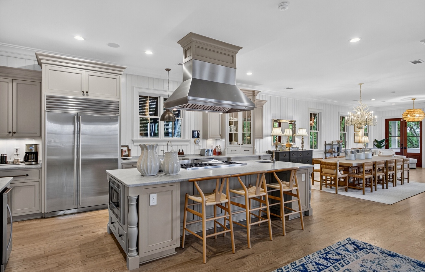 Prepare your favorite meals in this stunning chef's kitchen, complete with premium stainless steel appliances, spacious marble island with seating, and elegant flow into your inviting dining space.
