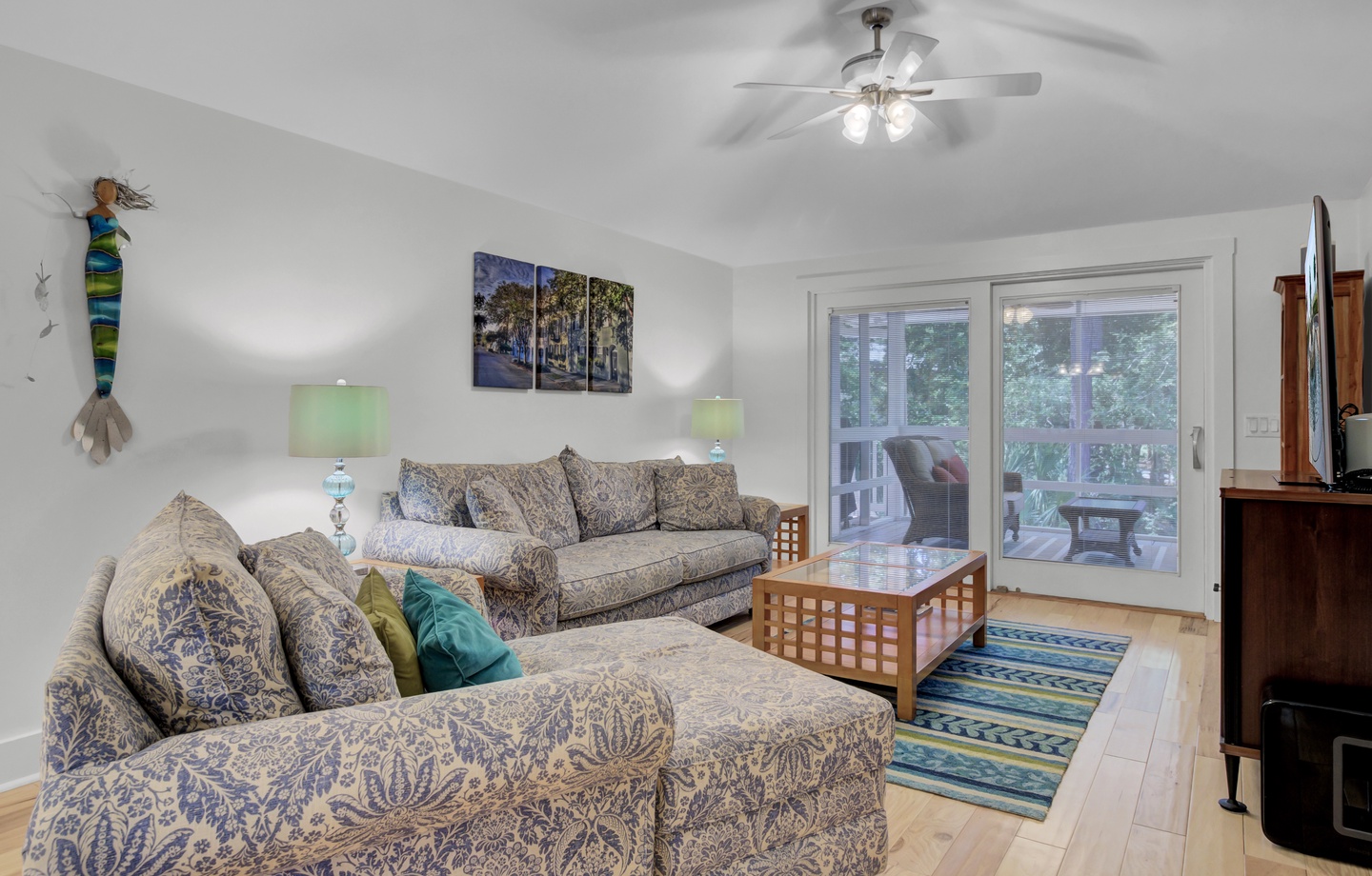 - Settle into cozy seating and soak up a space that’s both relaxed and stylish - Bright pops of color, cheerful lighting, and access to the outdoors add a breezy feel - Just a few steps from the screened porch, it’s perfect for easy indoor outdoor living