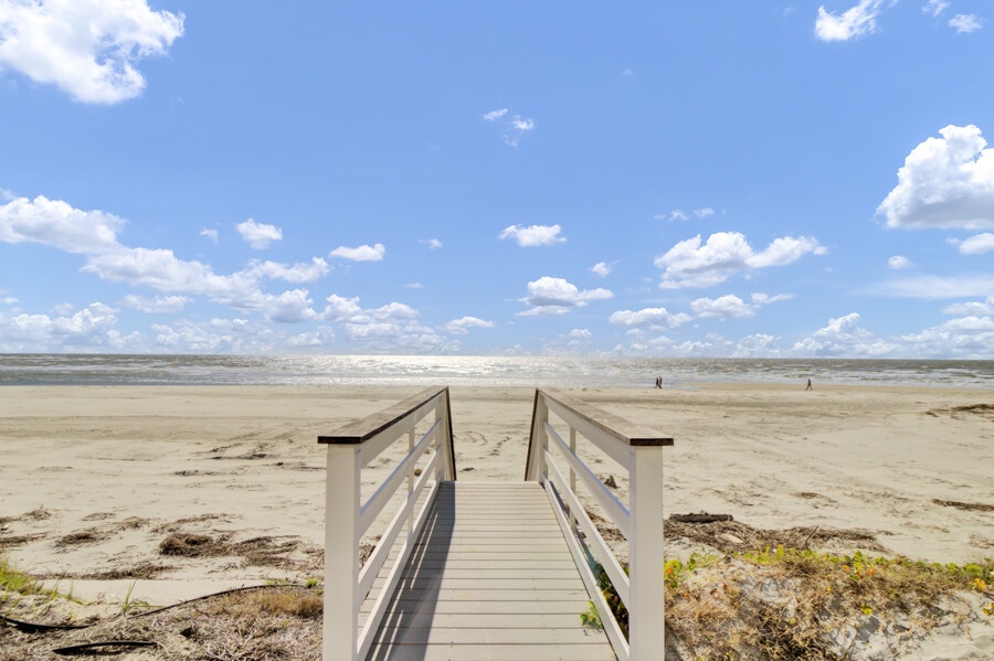 Direct beach access via a charming wooden path offering unobstructed ocean views and salty breezes.