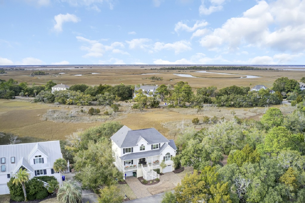 Elegant multi-story home nestled in beautiful greenery with sweeping marshland views stretching out to the horizon.