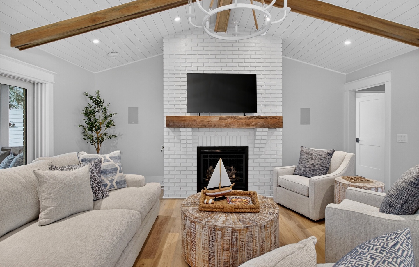Relax in your cozy living room with vaulted ceilings, exposed beams, and a stunning white brick fireplace perfect for quiet evenings together.