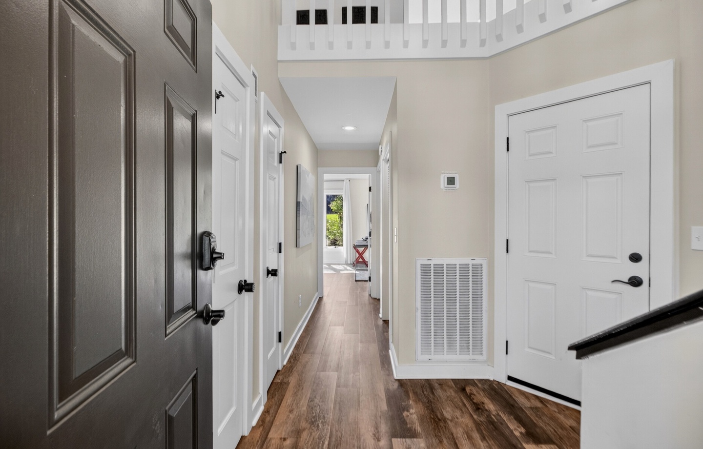 Step through the front door into your bright, welcoming hallway with gleaming wood floors leading you to comfortable living spaces and sunny outdoor views ahead.