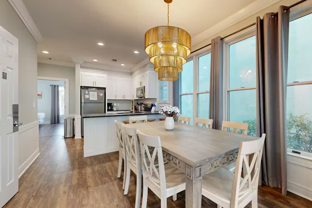 Your elegant dining room flows seamlessly into a fully-equipped kitchen, perfect for sharing memorable meals together under the warm glow of the statement chandelier.