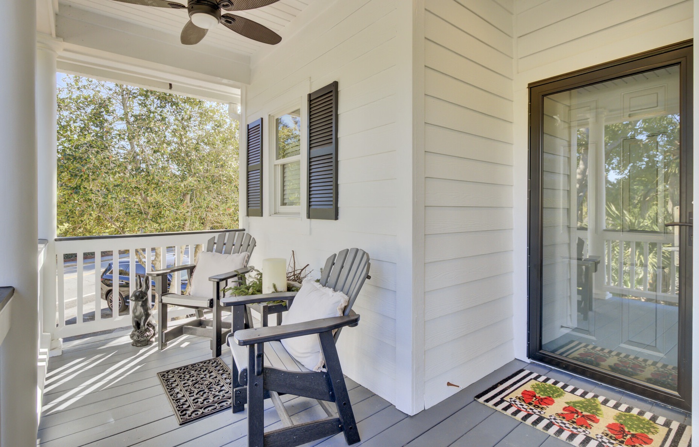 Your private covered porch invites peaceful mornings with comfortable chairs and gentle breezes from the ceiling fan overhead.
