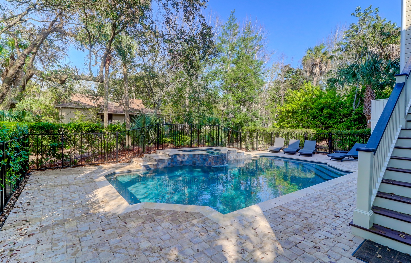 Your private oasis awaits with sparkling blue waters and lounge chairs ready for ultimate poolside relaxation.
