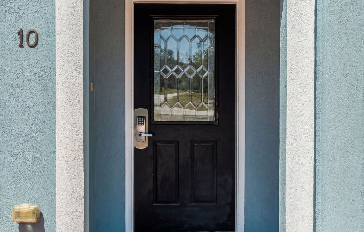 The entrance to your vacation retreat features a charming arched doorway with decorative glass, welcoming you to unit 10 with a keypad entry for easy, secure check-in.