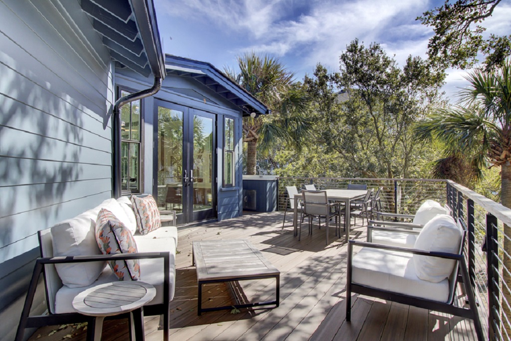 Relax in style on the spacious deck with plush seating and serene views of the trees - Savor alfresco meals at the sleek outdoor dining table for six guests - French doors open to blend indoor comfort with open air bliss