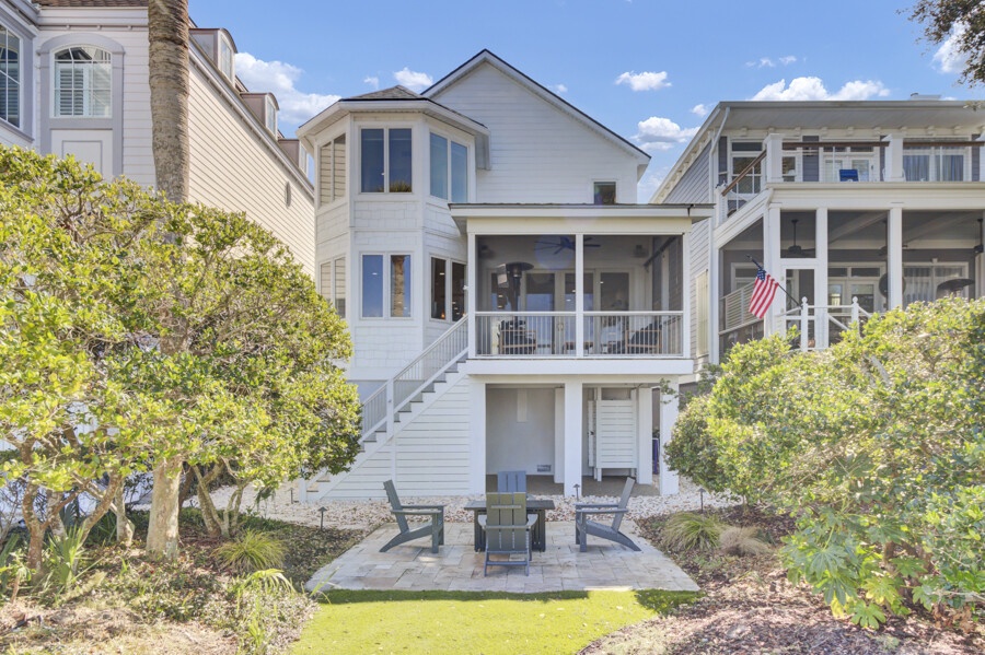 Charming coastal home with elevated deck overlooking peaceful grounds and mature landscaping in a quiet residential neighborhood.