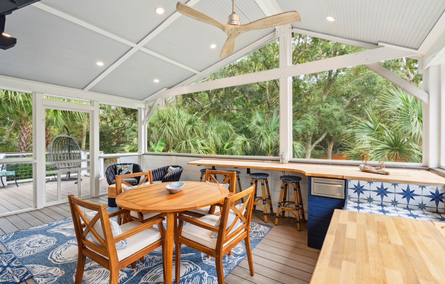 Sip your morning coffee surrounded by lush tropical views in this screened dining space. The breezy bar seating and cozy table invite you to gather and unwind.