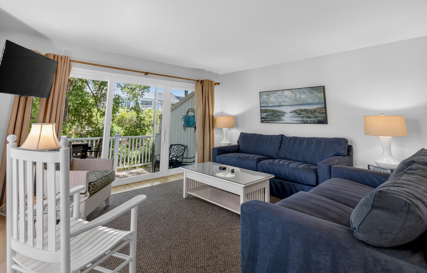Sink into plush navy sofas in your bright living space, where natural light streams through sliding doors to your private balcony retreat.
