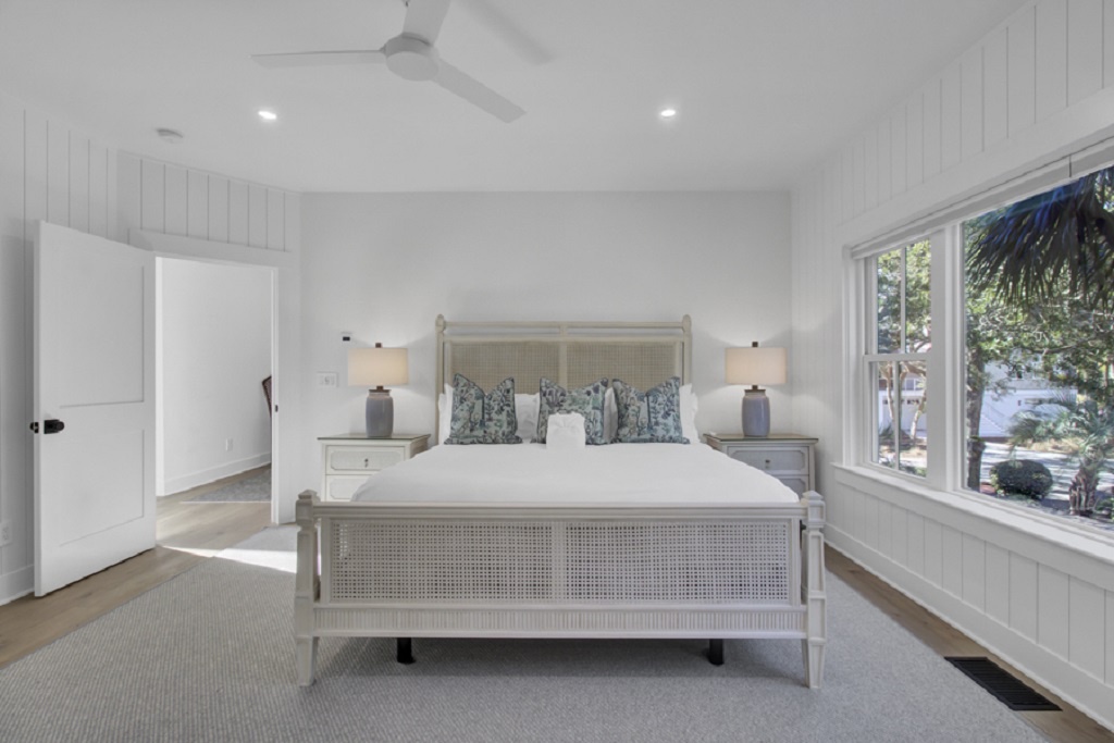 - Spacious bedroom with a plush king bed and coastal inspired textures for a peaceful escape - Crisp white walls, neutral tones, and modern lighting create a calming atmosphere - Large windows invite in natural light and views of greenery