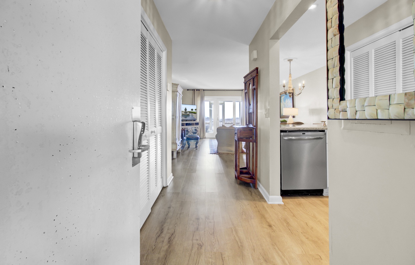 Step into your bright, open-concept space where elegant hardwood flows seamlessly from kitchen to living area, creating the perfect backdrop for your coastal getaway.