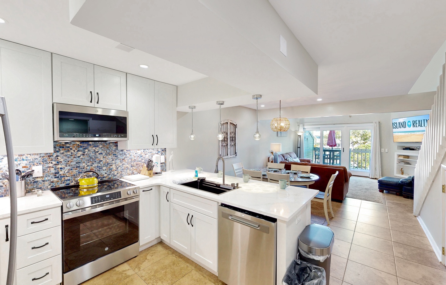 Your fully equipped kitchen opens to an inviting living space, perfect for preparing meals while staying connected with family and friends throughout your beach getaway.