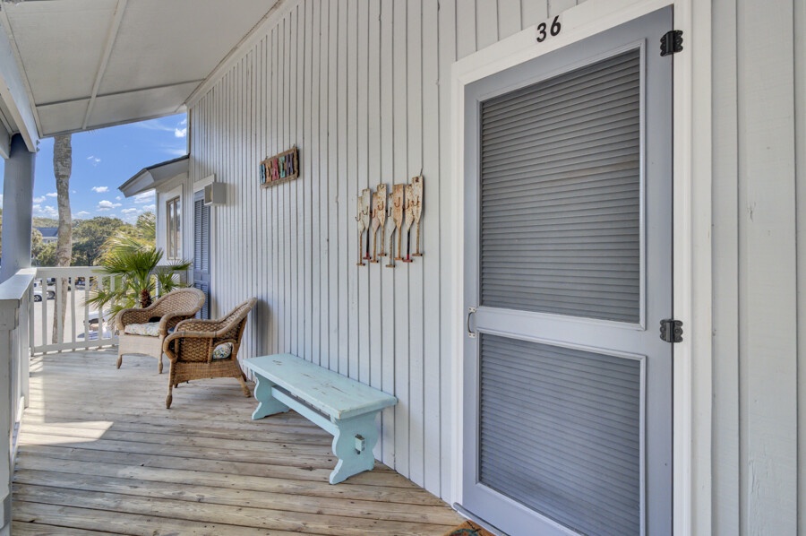 Your private balcony awaits with wicker seating and coastal charm, perfect for morning coffee while taking in those stunning tropical views.
