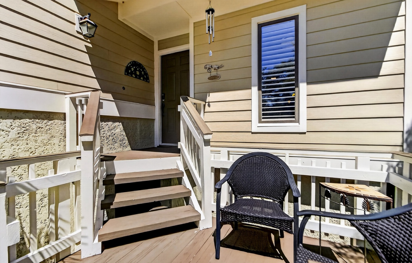 Step onto your private balcony, where comfortable wicker seating invites you to unwind with a book or morning coffee, while the coastal breeze drifts through this peaceful outdoor retreat.