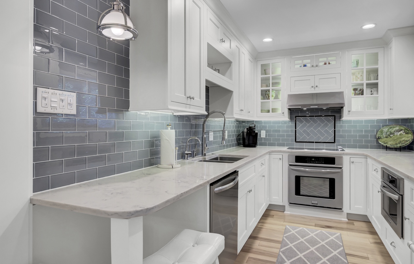 - Whip up meals or sip morning coffee in this crisp, modern kitchen with marble counters - Subway tile backsplash, pendant lighting, and stainless steel accents elevate the space - Grab a seat at the bar for breakfast, snacks, or late night chats