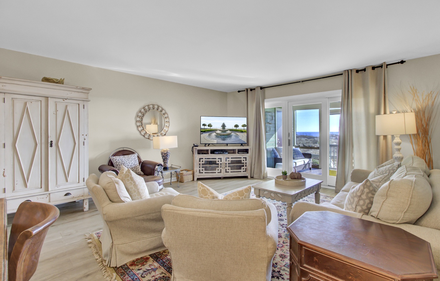 Settle into your bright, welcoming living room where beige tones create warmth and ocean views through sliding doors invite relaxation.