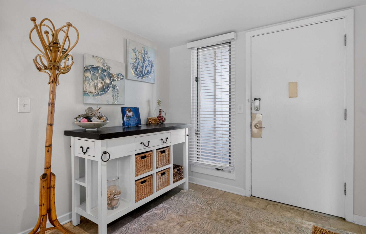 Step into your coastal retreat through this inviting entry, where beach-themed décor and thoughtful storage greet you. Natural light filters through the window, setting a relaxed, breezy tone for your stay.