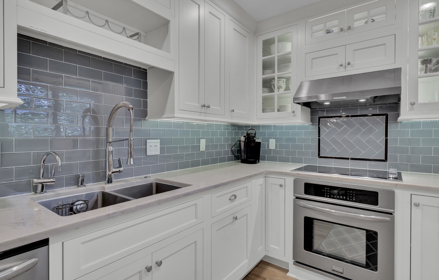 - Cook in style with sleek appliances, glass front cabinets, and a deep farmhouse sink - Soft gray blue backsplash adds a splash of personality to this clean, upscale kitchen - Whether you’re making coffee or dinner, this space is a joy to use