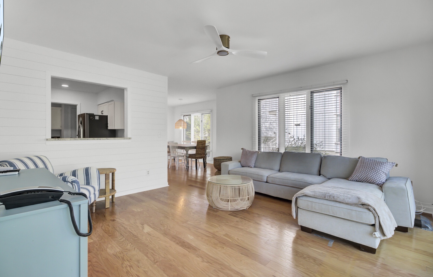 Unwind in your spacious living room featuring comfortable sectional seating, natural light streaming through large windows, and seamless flow to the modern kitchen.