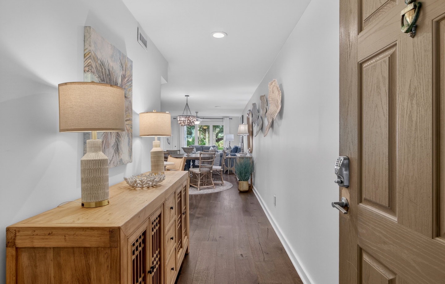 Step inside to warm wood tones and coastal-inspired décor guiding you toward a bright, open living and dining space—your inviting home base for a memorable getaway.