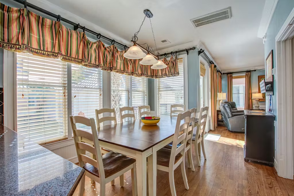 Gather around this spacious dining table where morning coffee flows and evening conversations linger under warm pendant lighting.