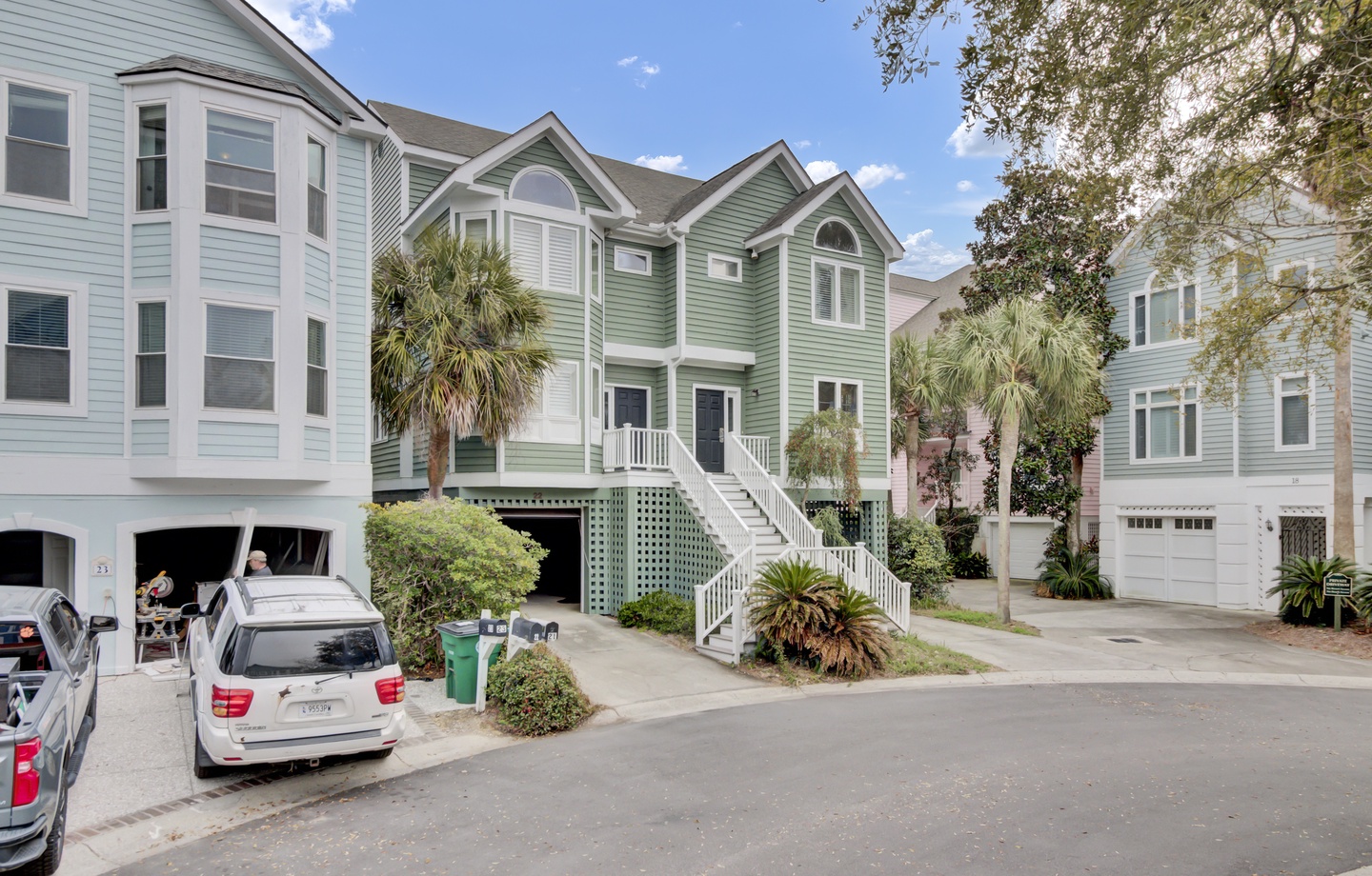 Charming coastal neighborhood with colorful beach houses and mature palm trees creates a welcoming atmosphere for your getaway.