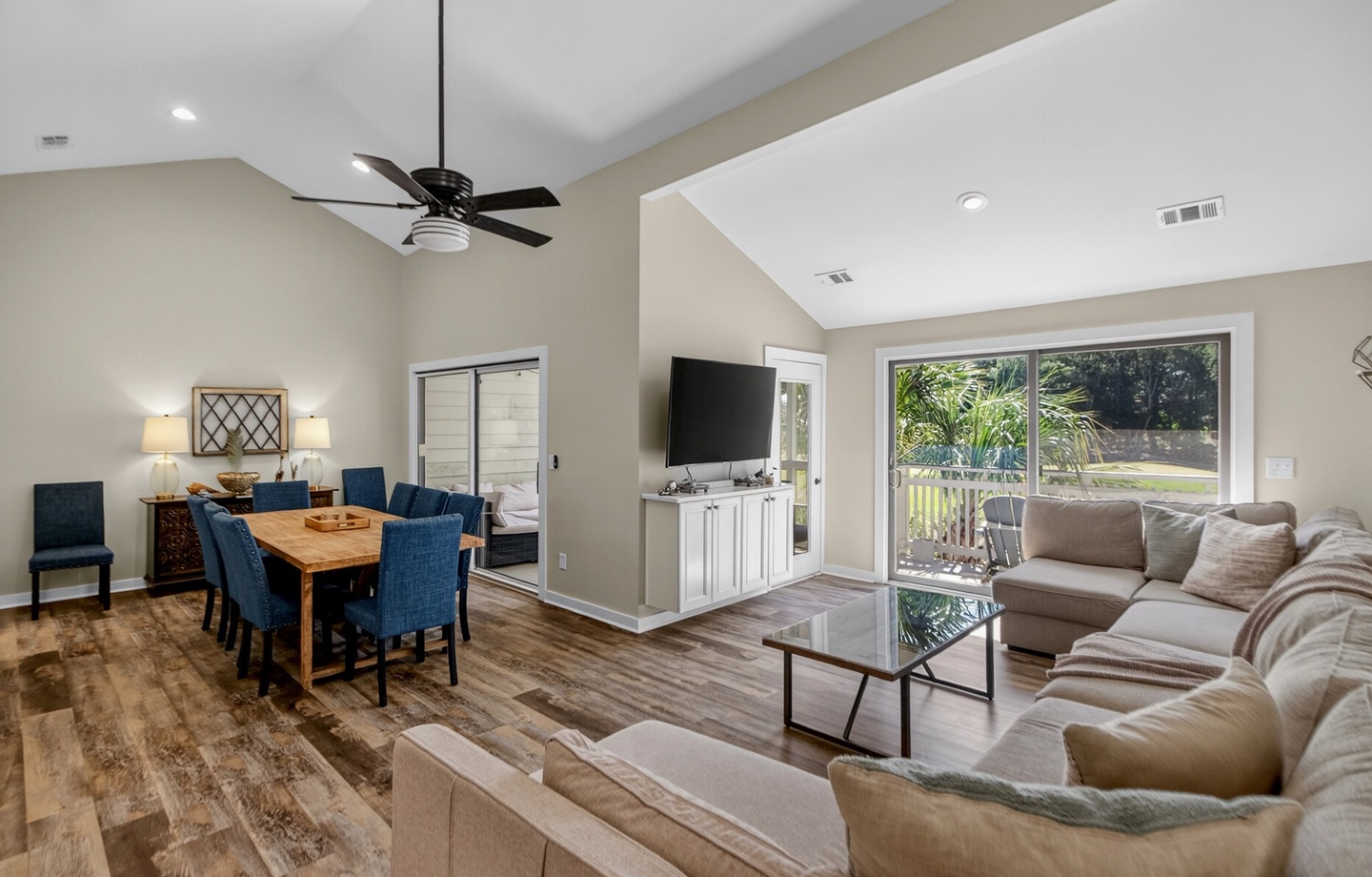 Step into this bright, open living space where vaulted ceilings and abundant natural light create an airy, welcoming atmosphere. Relax on plush seating, enjoy meals at the dining table, or step out to your private outdoor retreat.
