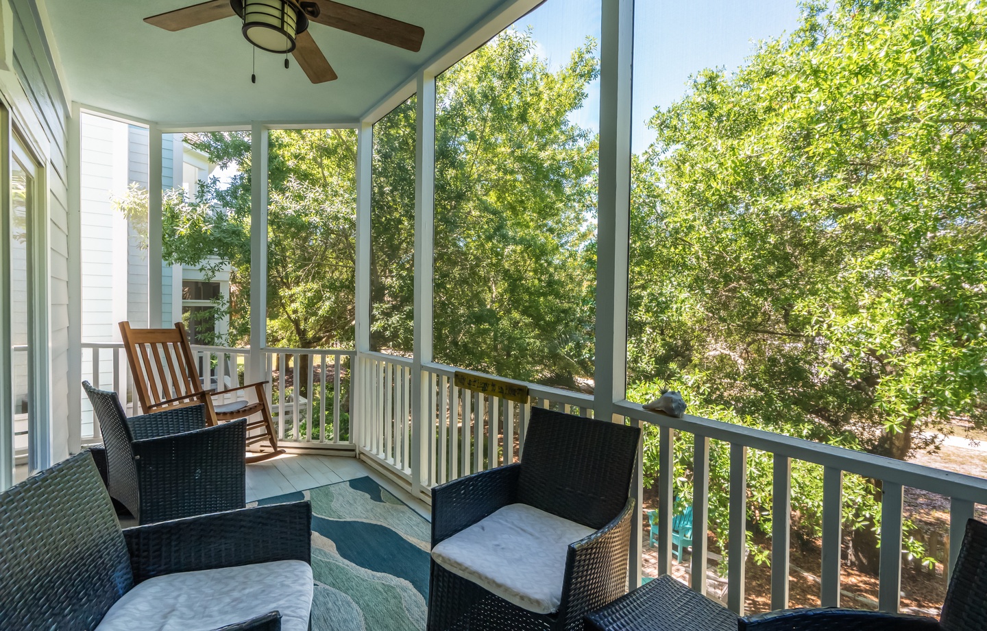 Relax in your screened porch with comfy seating and a gentle breeze from the ceiling fan as you gaze into lush, leafy treetops.