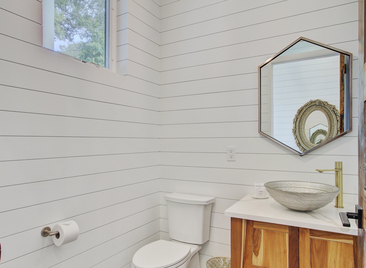 Unwind in this stylish powder room featuring white shiplap walls and warm wood accents that create a perfect blend of farmhouse charm and modern comfort.