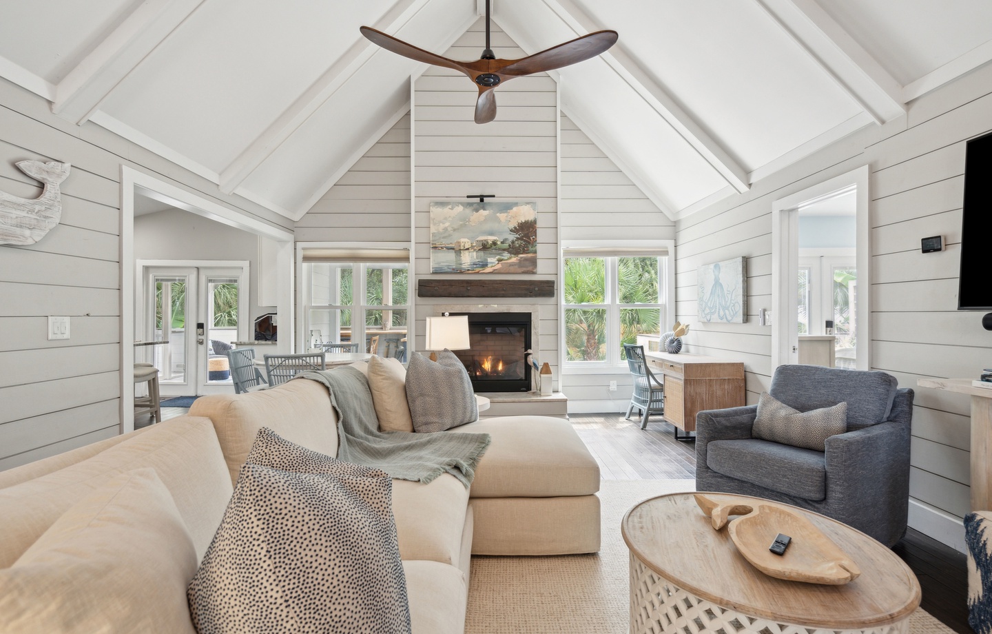 Sink into plush seating beneath soaring vaulted ceilings, where natural light pours through wall-to-wall windows and a cozy fireplace awaits to warm your evenings after exploring nearby adventures.