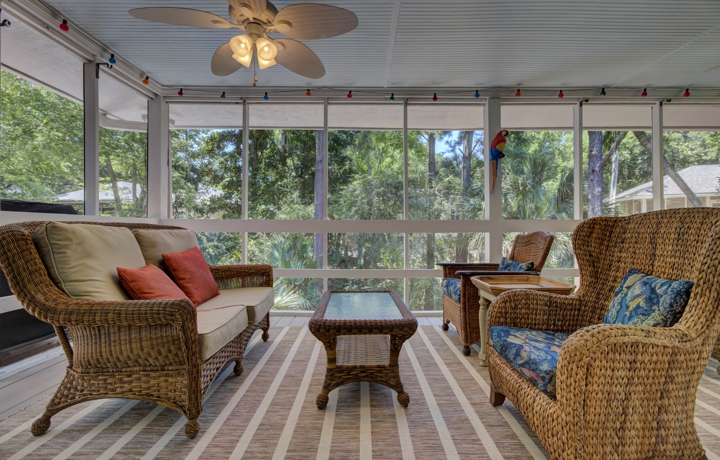 - Lounge in comfort on this charming screened porch surrounded by greenery - Wicker sofas and soft cushions invite you to kick back and relax in the breeze - Perfect spot for morning coffee, afternoon chats, or evening wine under the fan