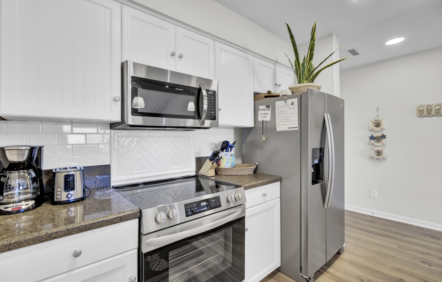 - Cook up your favorites with a stainless steel oven, microwave, and full size fridge - Sleek counters and white cabinetry offer a fresh, functional space for every meal - Whether it’s coffee at sunrise or dinner after the beach, this kitchen has you cove
