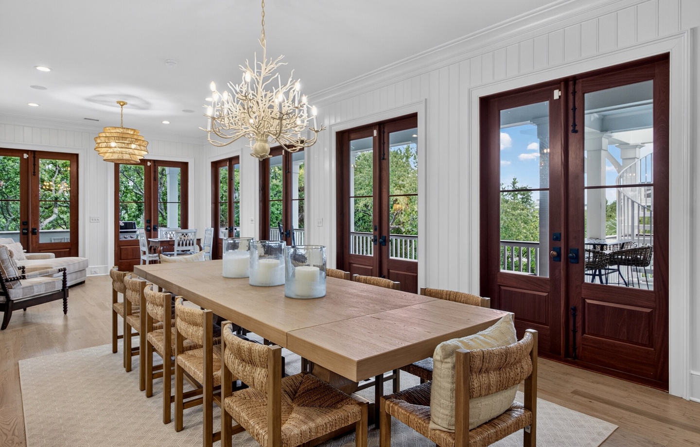 Step into this elegant dining space where a stunning chandelier illuminates your meals. Floor-to-ceiling French doors open to lush greenery and a peaceful balcony retreat.