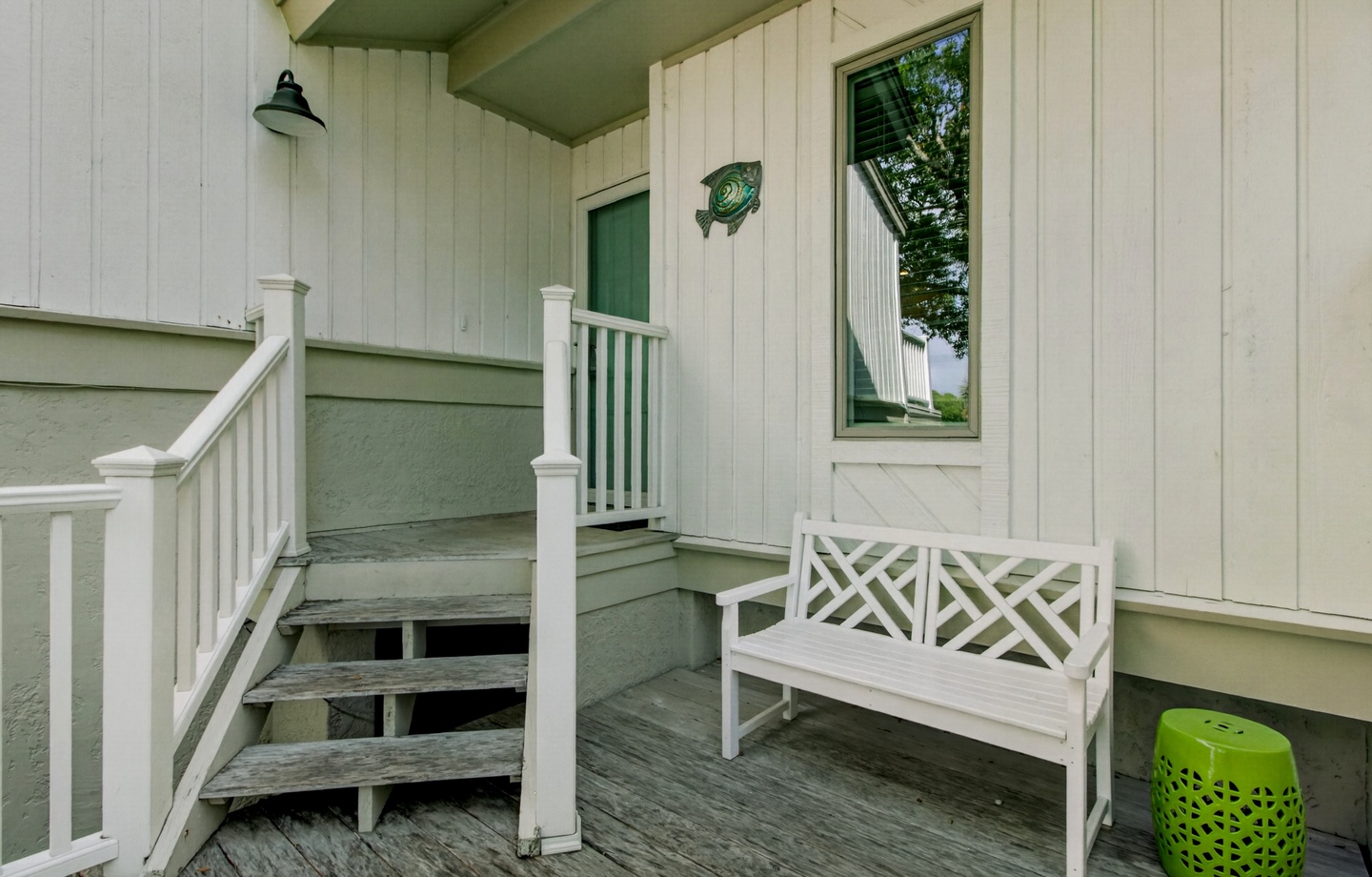 Step onto your welcoming covered porch, featuring a charming bench where you can sit and relax after your lakeside adventures.
