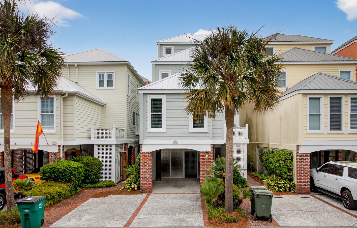 Charming coastal townhomes with palm trees and brick accents create a welcoming beachside community setting.