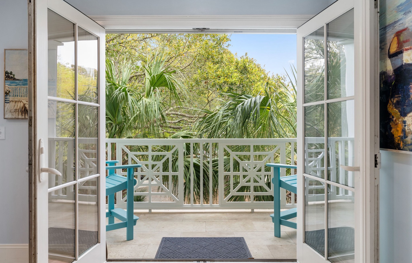 Step onto your private balcony where tropical palms frame your peaceful retreat and turquoise chairs invite you to unwind.